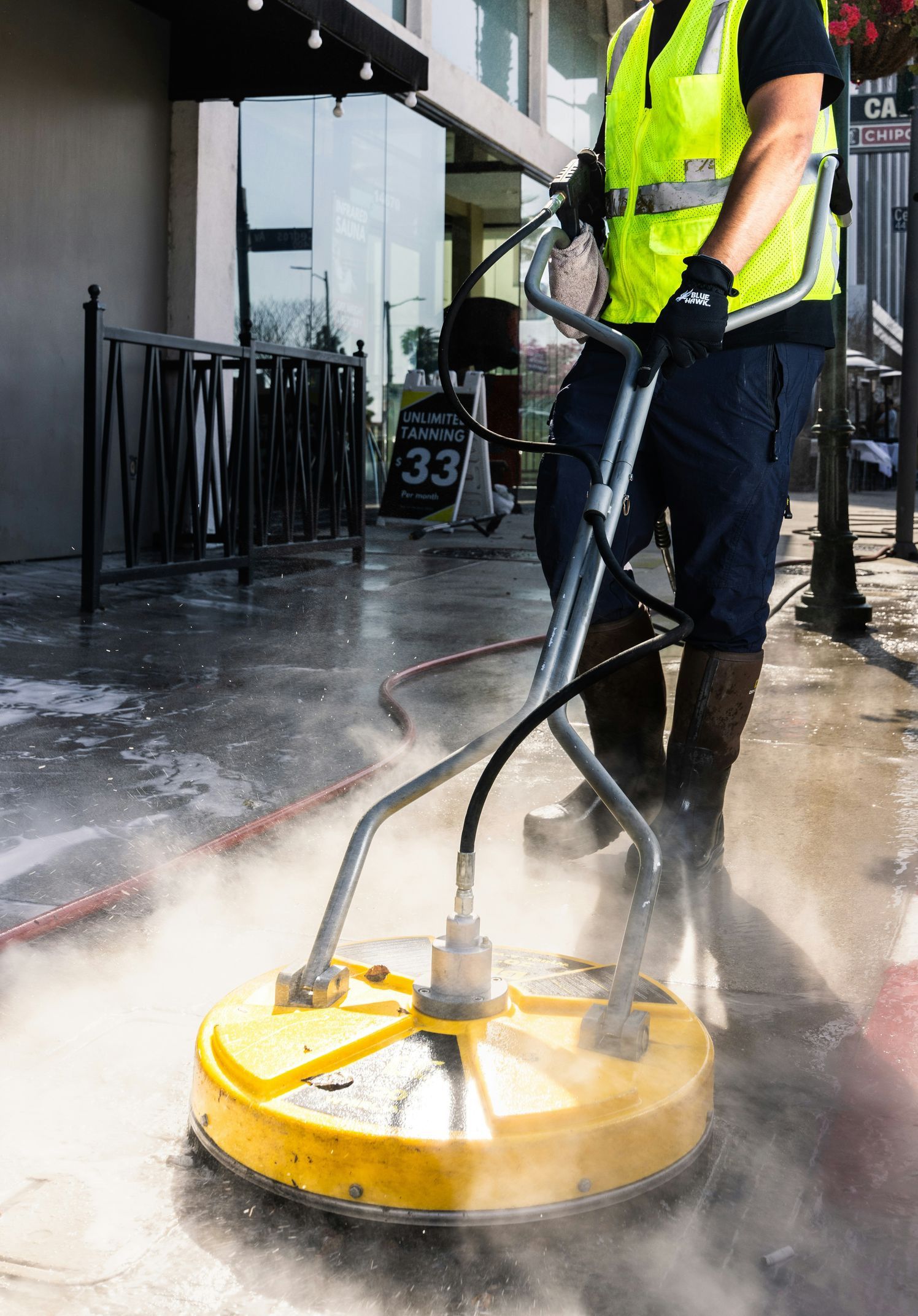 a man in a yellow vest is cleaning the street